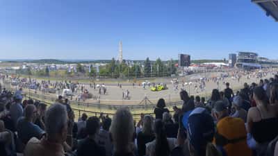 Vista aérea do paddock das 24 Horas de Nürburgring com equipas e carros alinhados na grelha de partida