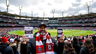 AFL fan outside the MCG holding finals tickets and a phone showing a resale listing