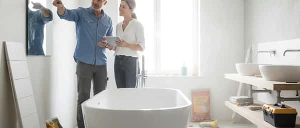 Artisan plombier installant une douche à l'italienne dans une salle de bain en rénovation