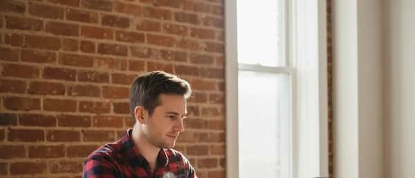 Informaticien freelance québécois travaillant sur un laptop dans un appartement du Plateau à Montréal