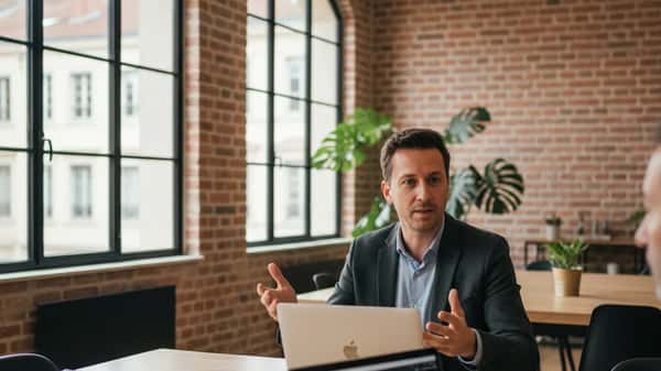 Développeur web freelance discutant d'un projet dans un espace de coworking à Lyon, lumière naturelle