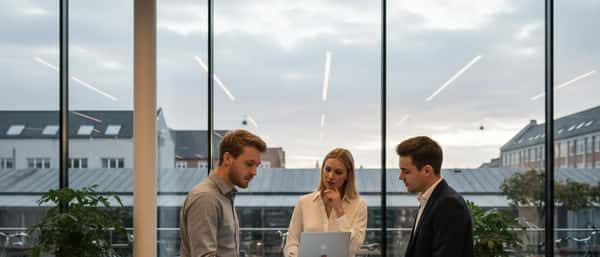 Dansk mand undersøger en bærbar computer i en skandinavisk elektronikbutik med rene linjer og birketræshylder