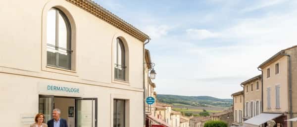 Dermatologist examining a patient forearm with a dermatoscope in a bright Scandinavian clinic in Reykjavík