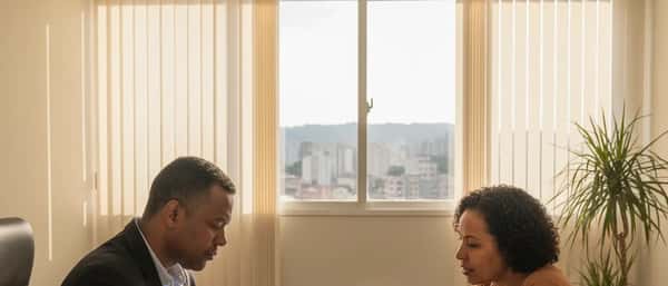 Advogado previdenciário atendendo cliente em escritório em Belo Horizonte, revisando documentos do INSS