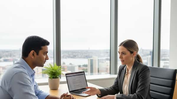 Immigration lawyer consulting with a client in a modern Sydney law office, reviewing visa documents across a timber desk