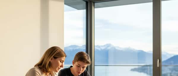 Mère et adolescent travaillant ensemble sur des manuels scolaires dans un appartement genevois