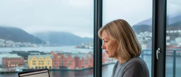 Nordisk kvinne som gjennomgår pensjonsdokumenter ved et skrivebord i en moderne norsk leilighet