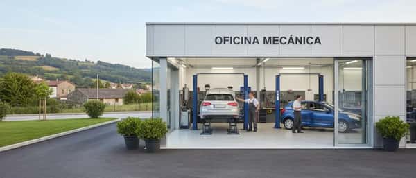 Mecânico brasileiro inspecionando motor de carro com scanner de diagnóstico em oficina mecânica organizada