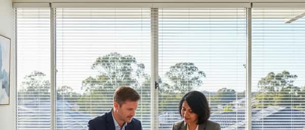 Financial advisor and client reviewing documents together in a modern Sydney office with natural light