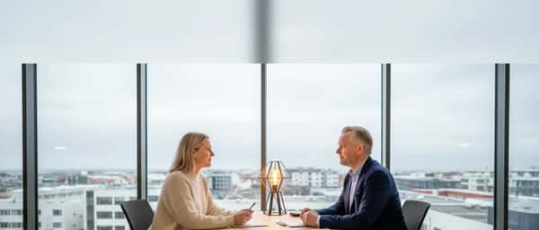 Fjármálaráðgjafi ráðleggur viðskiptavini í nútímalegu skrifstofu í Reykjavík