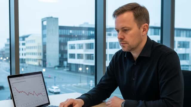 Fjármálaráðgjafi skoðar efnahagsspá Landsbankans á fartölvu í Reykjavíkurskrifstofu