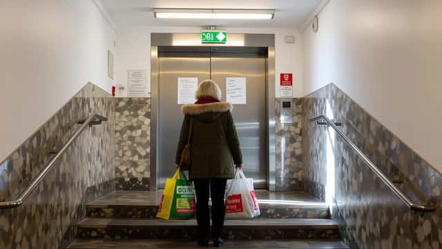 Locataire face à un ascenseur hors service dans un immeuble suisse