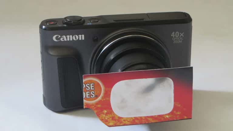Appareil photo Canon avec filtre solaire sur l'objectif, prêt à photographier l'éclipse solaire
