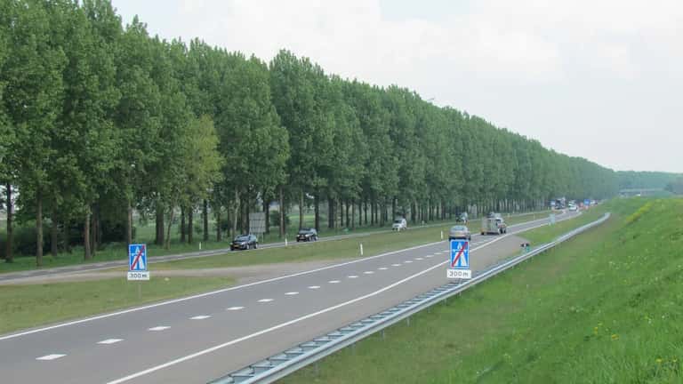A15 snelweg bij Bemmel, Nederland — druk vrachtverkeer langs woonwijken