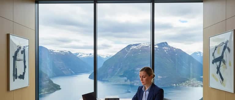 Norsk advokat som gjennomgår internasjonale juridiske dokumenter på et moderne kontor med fjordutsikt