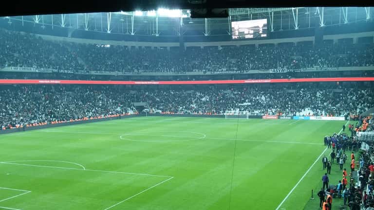 Beşiktaş voetbalwedstrijd in stadion, spelers in zwart-wit tenue op het veld