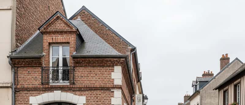 Buitenkant van een typische Nederlandse huisartsenpraktijk met bakstenen gevel en geparkeerde fietsen