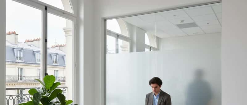 Modern Icelandic clinic waiting room with Scandinavian birch-wood furniture and overcast sky through window
