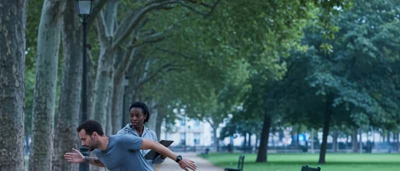 Séance de coaching sportif en extérieur dans un parc parisien avec arbres et allée de gravier