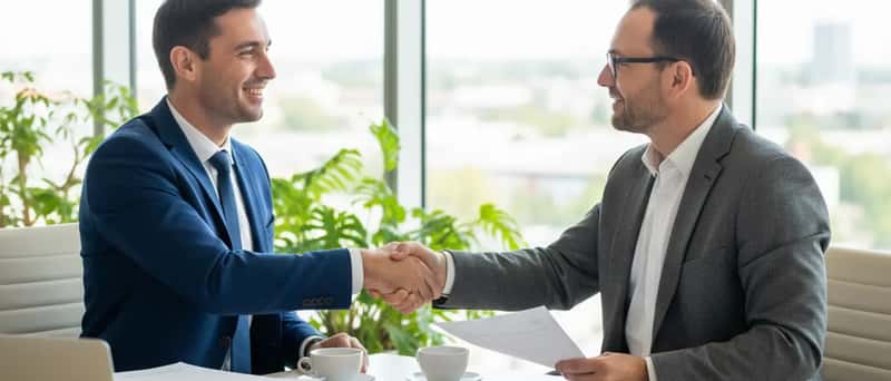 Entrepreneur et comptable échangeant dans un bureau moderne après une réunion de travail
