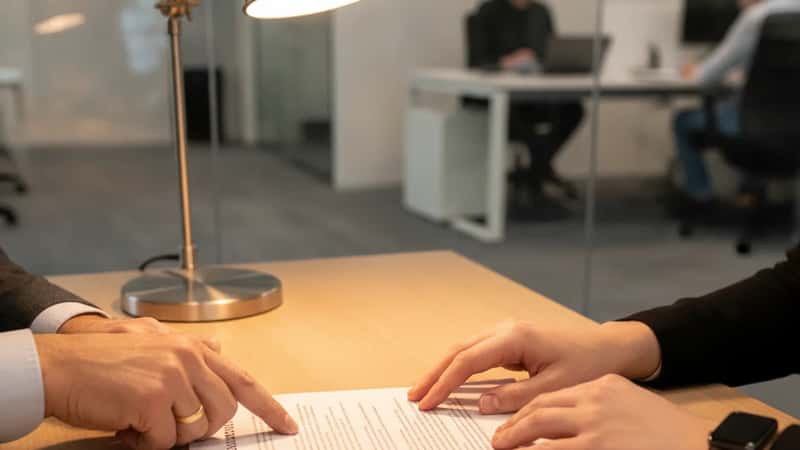 HR-professional en werknemer bekijken samen een arbeidscontract op kantoor in Rotterdam