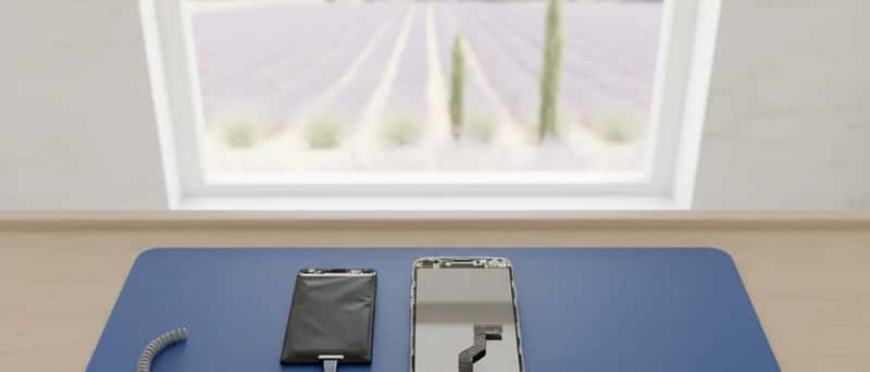 Demonterte smarttelefonkomponenter lagt ut på en antistatisk matte i et reparasjonsverksted