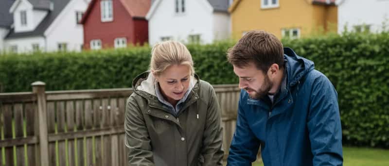 Huseier og gartner gjennomgår en hageplan sammen ved et utebord