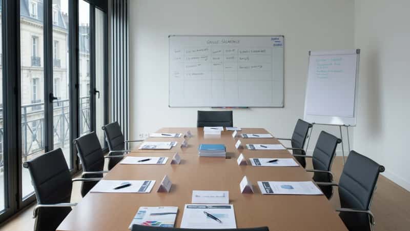 Salle de réunion d'une association d'aide au logement à Nantes avec documents de convention collective posés sur la table