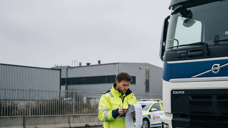 Norsk vegvesen-kontrollør gjennomgår tachografdata ved lastebil på vei nær Trondheim