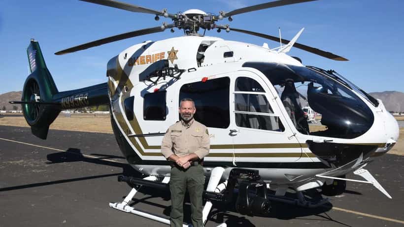 Sheriff Chad Bianco standing with Riverside County Sheriff helicopter