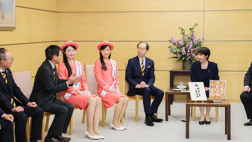 Japanese Prime Minister Sanae Takaichi receiving a traditional food gift from the Governor of Fukushima Prefecture at an official ceremony