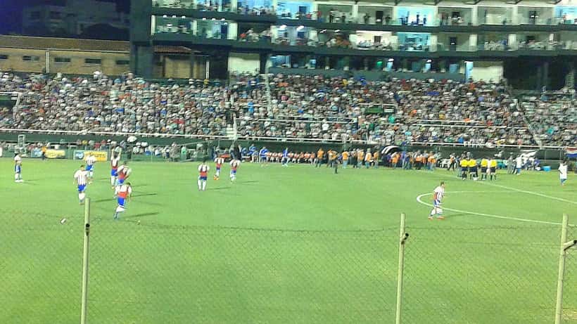 Joueurs du Paraguay en match international, gardien et défenseurs en action sur terrain de football