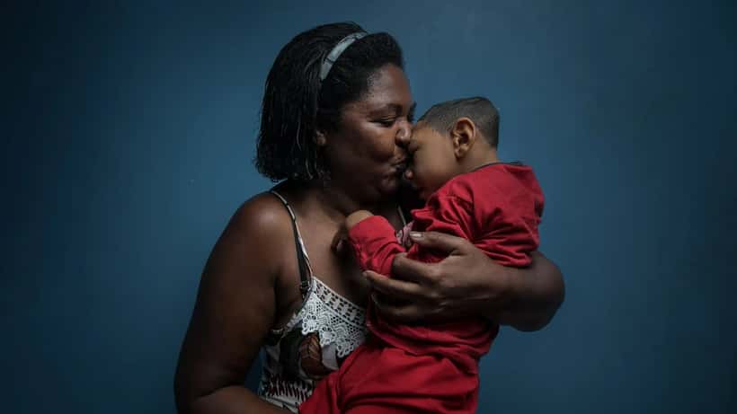 Mãe abraçando filho em imagem documental sobre família e adoção