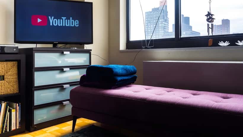 Person streaming YouTube TV content on a laptop with channel selection visible