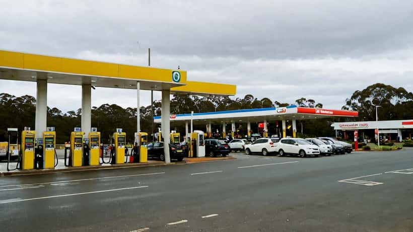 Australian petrol station with high fuel prices on display, cars at pumps