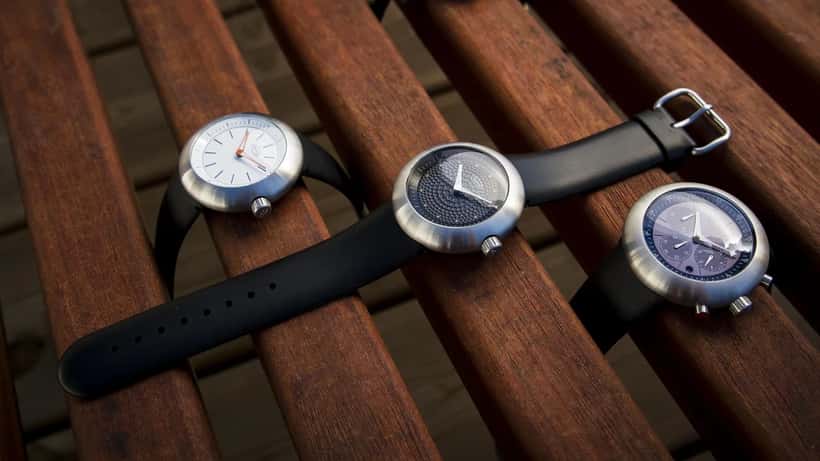 Trois montres suisses de design de la collection Ikepod, posées sur fond sombre