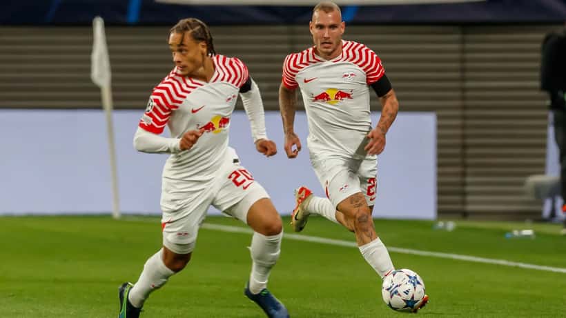 Xavi Simons em ação pela Liga dos Campeões com RB Leipzig, ilustrando esforço físico de atleta jovem de elite