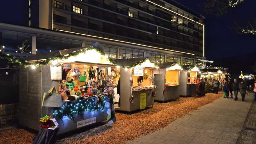 Weihnachtsmarktstand in Österreich mit Adventdekoration und Holzhäuschen