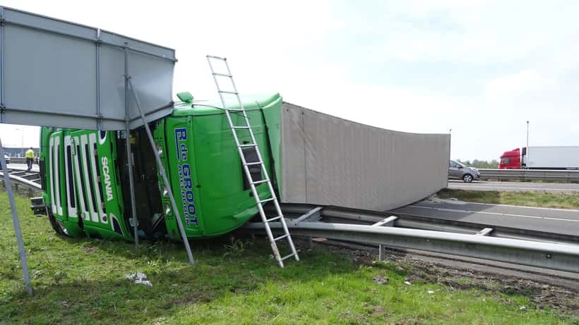 Camion accidenté sur autoroute après collision avec une voiture, dégâts visibles sur la remorque