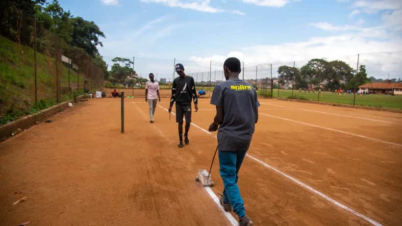 Trabajador marcando las líneas de una pista de tenis de arcilla antes de un torneo profesional