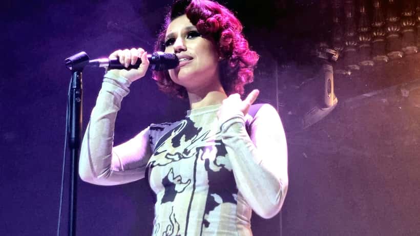 RAYE performing live on stage at a UK venue, singer and songwriter
