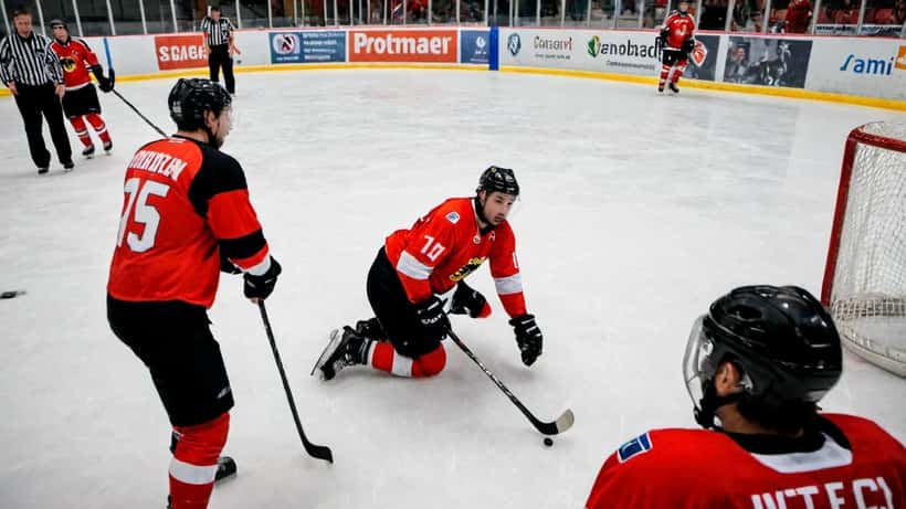Eishockeyspieler stürzt auf dem Eis — typische Sportverletzungen im Eishockey