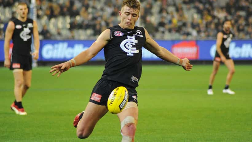Patrick Cripps kicking during an AFL match for Carlton