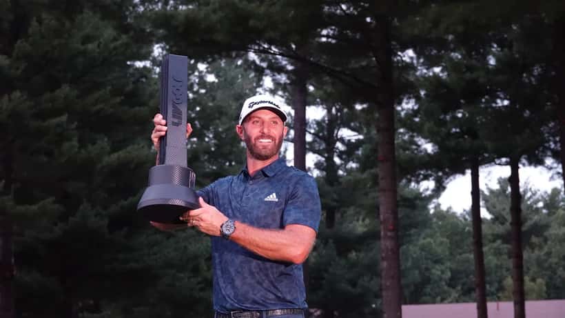 Dustin Johnson champion du LIV Golf Boston, tenant son trophée sur le green