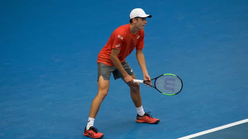 Joueur de tennis professionnel sur court en terre battue à Monte-Carlo lors d'un match de Masters
