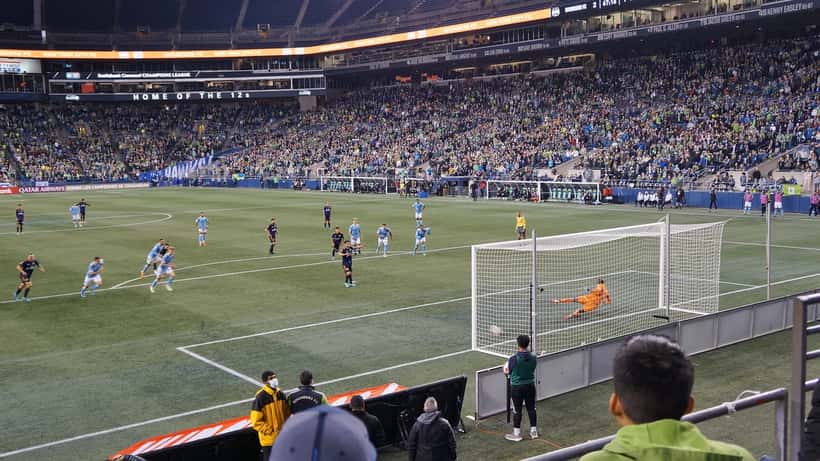 Cobrança de pênalti em jogo da CONCACAF Champions League, representando as apostas esportivas no futebol internacional