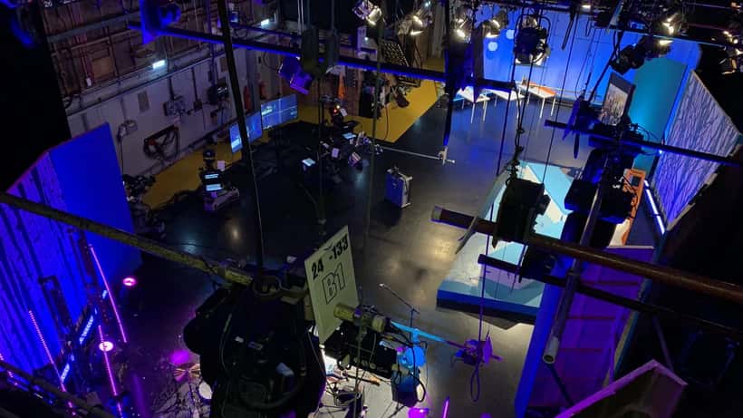 Estúdio de televisão com câmaras e luzes preparado para gravação de uma série de ficção