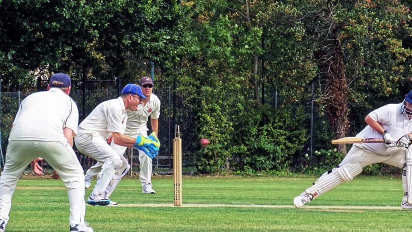 Cricket match in progress with batsman and wicketkeeper, illustrative of T20 cricket action