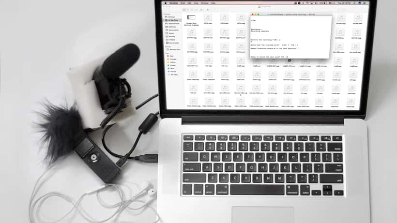 Podcast-studie med mikrofon og Spotify-app åben på bærbar computer