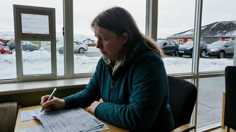 Íslenska kona fer yfir reikninga á meðan verðlag hækkar á Íslandi 2026